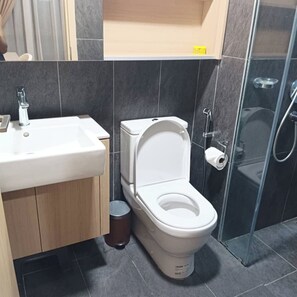 A modern bathroom with a toilet, sink, and shower.
