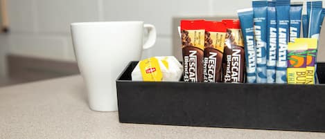 A tray with various coffee pods and a white mug on a countertop.