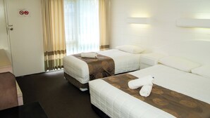 A hotel room with two beds, a desk, and a door with a no-smoking sign. - Ocean Views Motel Lakes Entrance (Kalimna)
