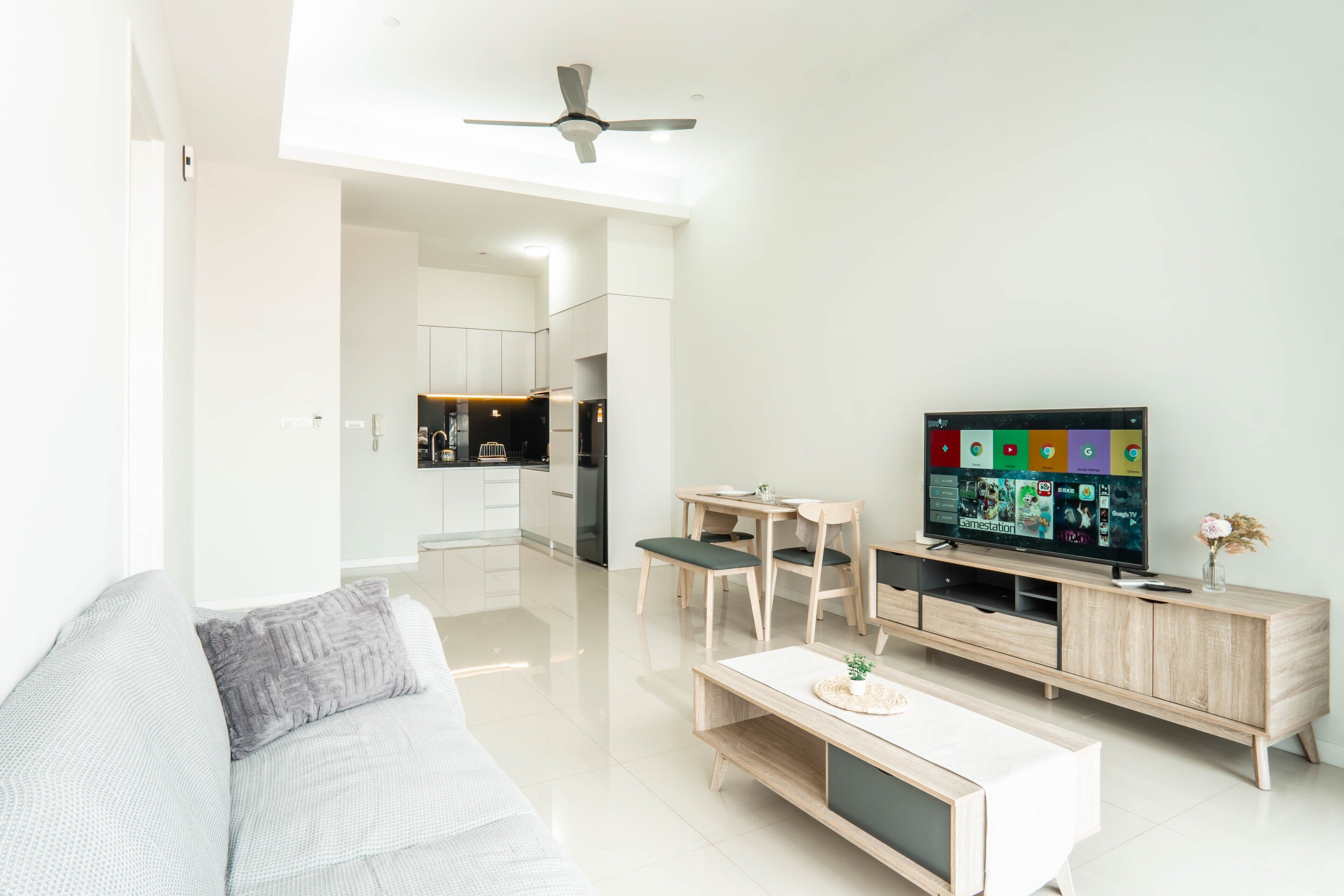 A modern living room with a sofa, coffee table, TV, and wooden entertainment unit.