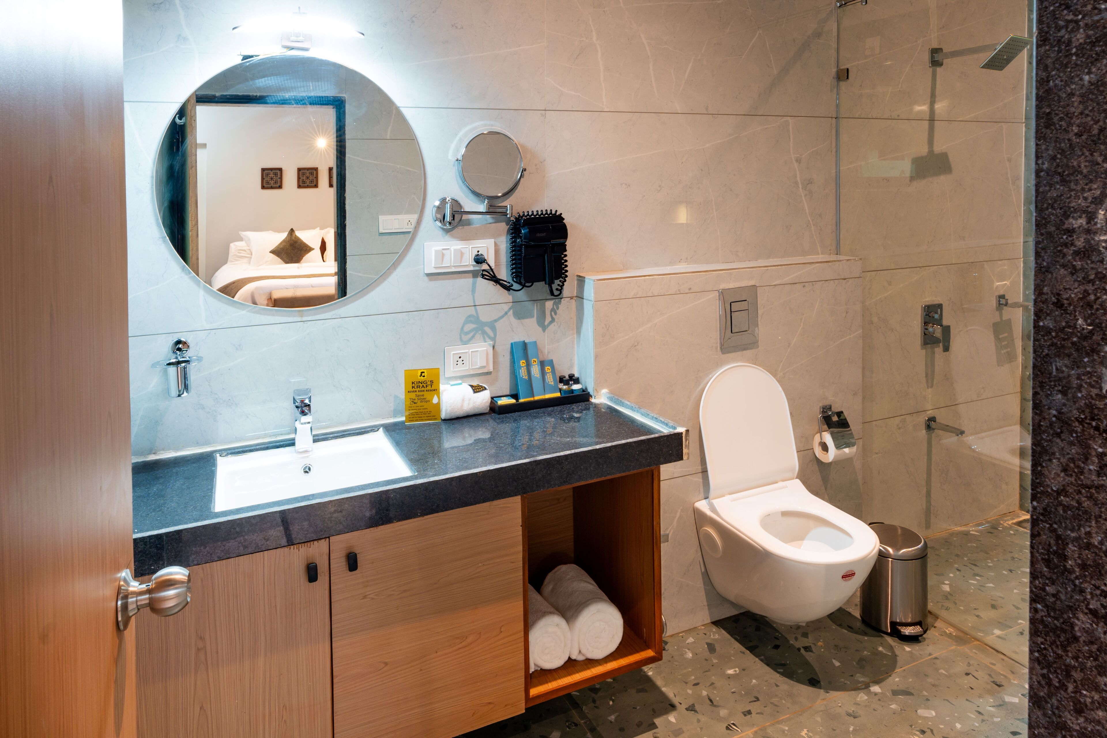 A modern bathroom with a sink, mirror, toilet, and shower.