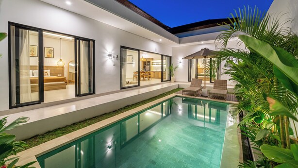 A modern house with a swimming pool, large windows, and outdoor seating.