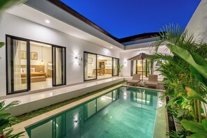 A modern house with a swimming pool, large windows, and outdoor seating. - Villa Castillo Modern 2 BR Villa in Canggu w/ Aircon Living (Badung)
