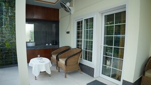 A room with a dining table and chairs, a kitchen area, and a sliding glass door leading to a balcony.