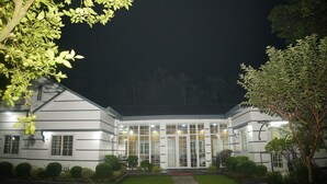 A modern building with a symmetrical facade, large windows, and a well-maintained lawn.
