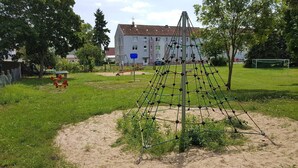 Un parque infantil con estructuras para escalar y columpios.