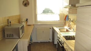 Cocina compacta con microondas, horno y lavabo.