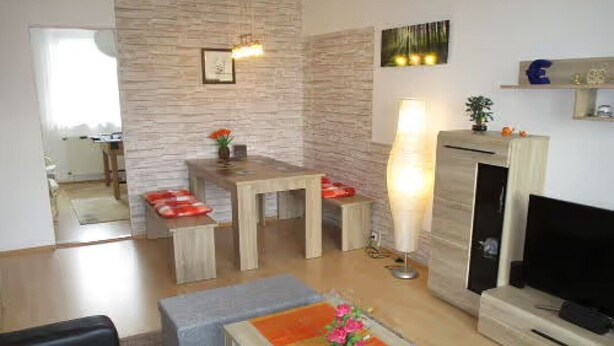 Una sala de estar con televisión, chimenea, mesa de comedor y sofá.