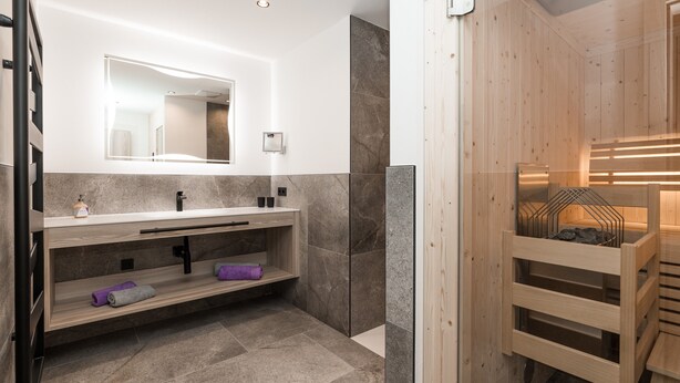 Een moderne badkamer met een houten wastafelmeubel, een grote spiegel en een sauna.