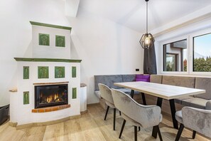 A modern interior with a fireplace, seating area, and a large window.