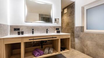 Une salle de bain moderne avec un double vasque, un grand miroir et un porte-serviettes intégré.