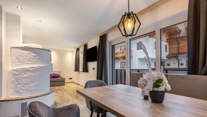 Un comedor moderno con una mesa de madera, sillas y un jarrón de flores blancas.