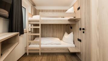 Dormitorio con literas, paredes de madera y ventana.