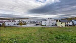 Un puerto deportivo con barcos, una zona de estacionamiento y edificios residenciales de techos planos.