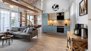 A spacious living area with a modern kitchen, a staircase, and a large window. - Holiday Apartment 'Seeschwalbe - Marina Mücheln' with Lake View, Wi-Fi & Air Conditioning (Mücheln (Geiseltal))