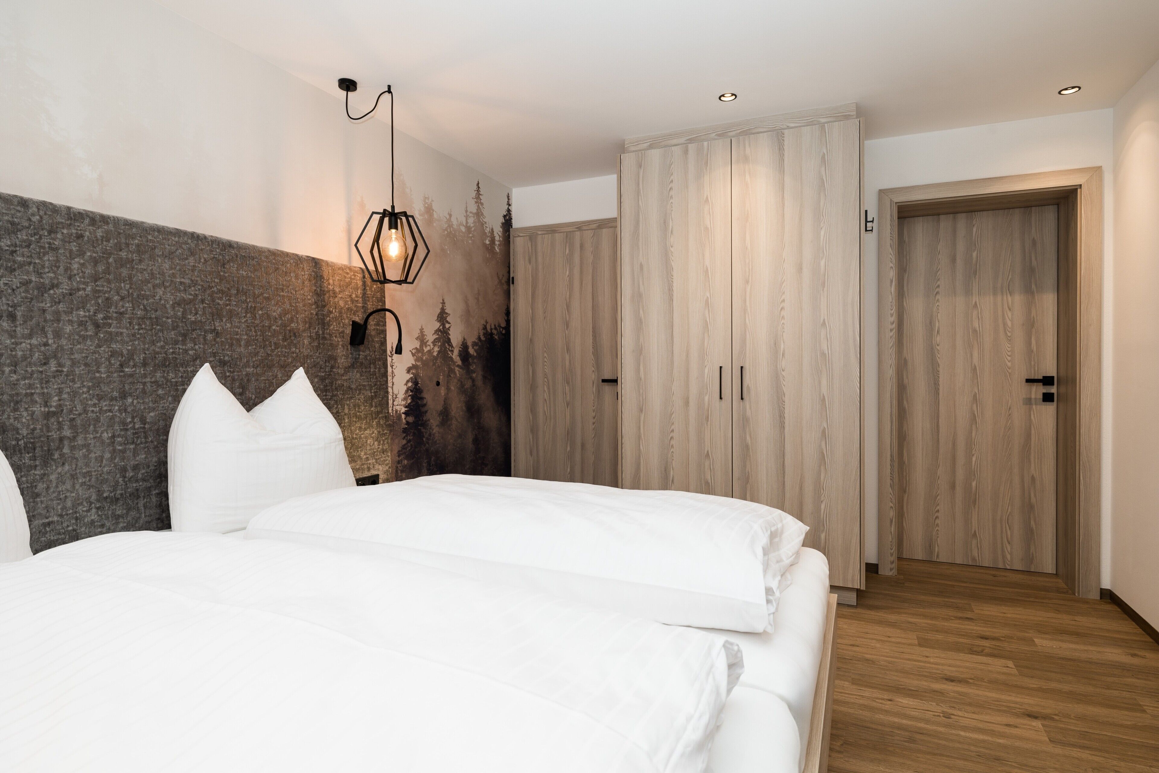 Un dormitorio con una cama, una lámpara de pared y un armario.
