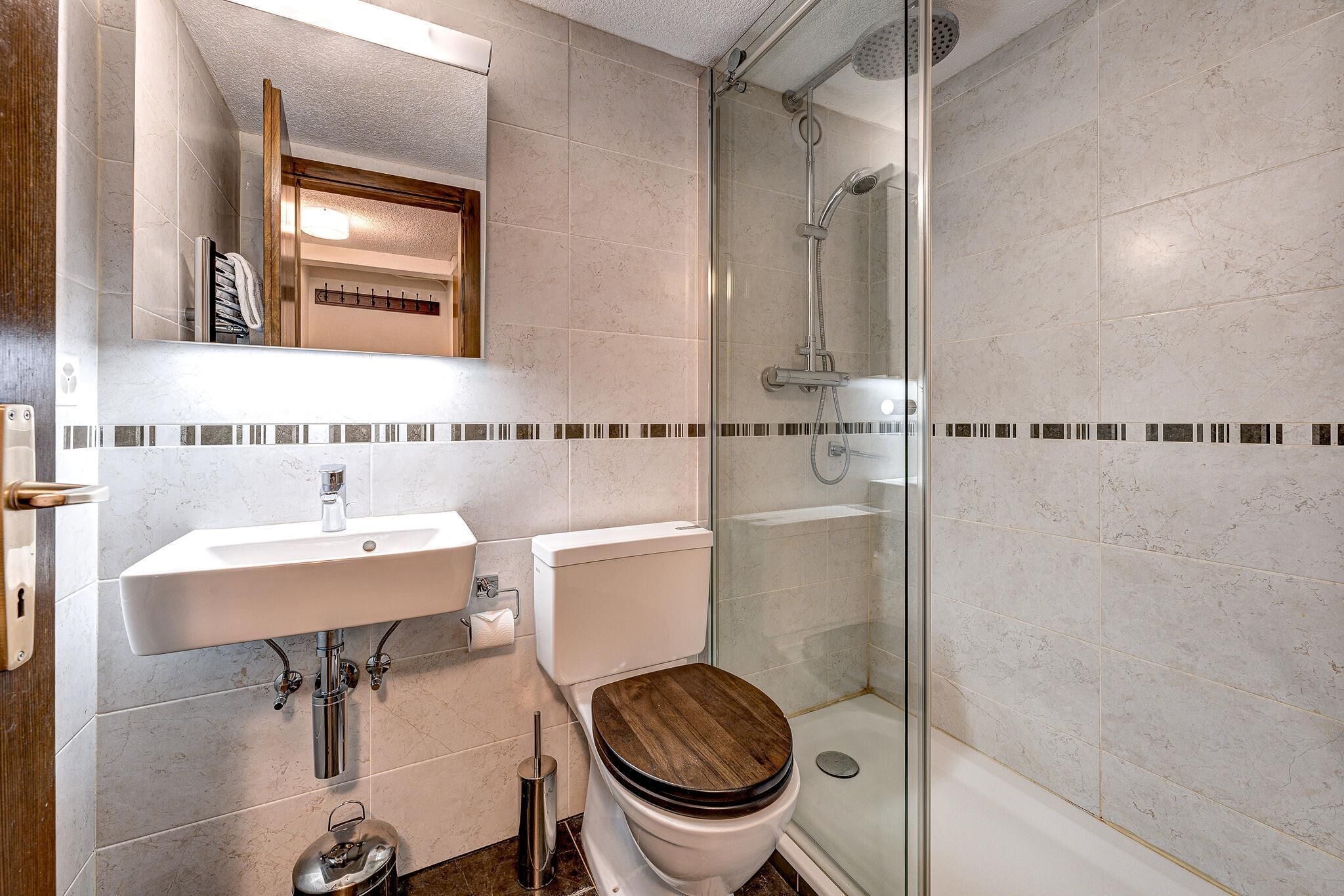 A bathroom with a toilet, sink, and shower.