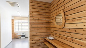 Una sala de sauna con paredes de madera, un banco y un espejo.