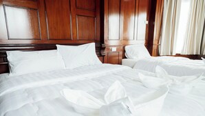 A hotel room with two beds, wooden paneling on the walls, and a window with curtains. - The Star Pool Villa Hatyai (Hat Yai)
