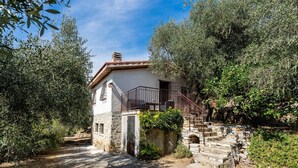 A rustic stone house with a balcony, surrounded by olive trees and a gravel path. - Beautiful private villa for 4 guests with TV, balcony, pets allowed and panoramic view (Diano San Pietro)