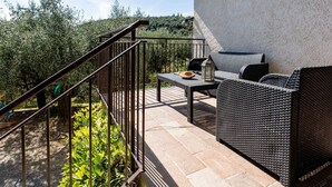 An outdoor patio with wicker furniture, a metal railing, and a view of greenery and hills. - Beautiful private villa for 4 guests with TV, balcony, pets allowed and panoramic view (Diano San Pietro)