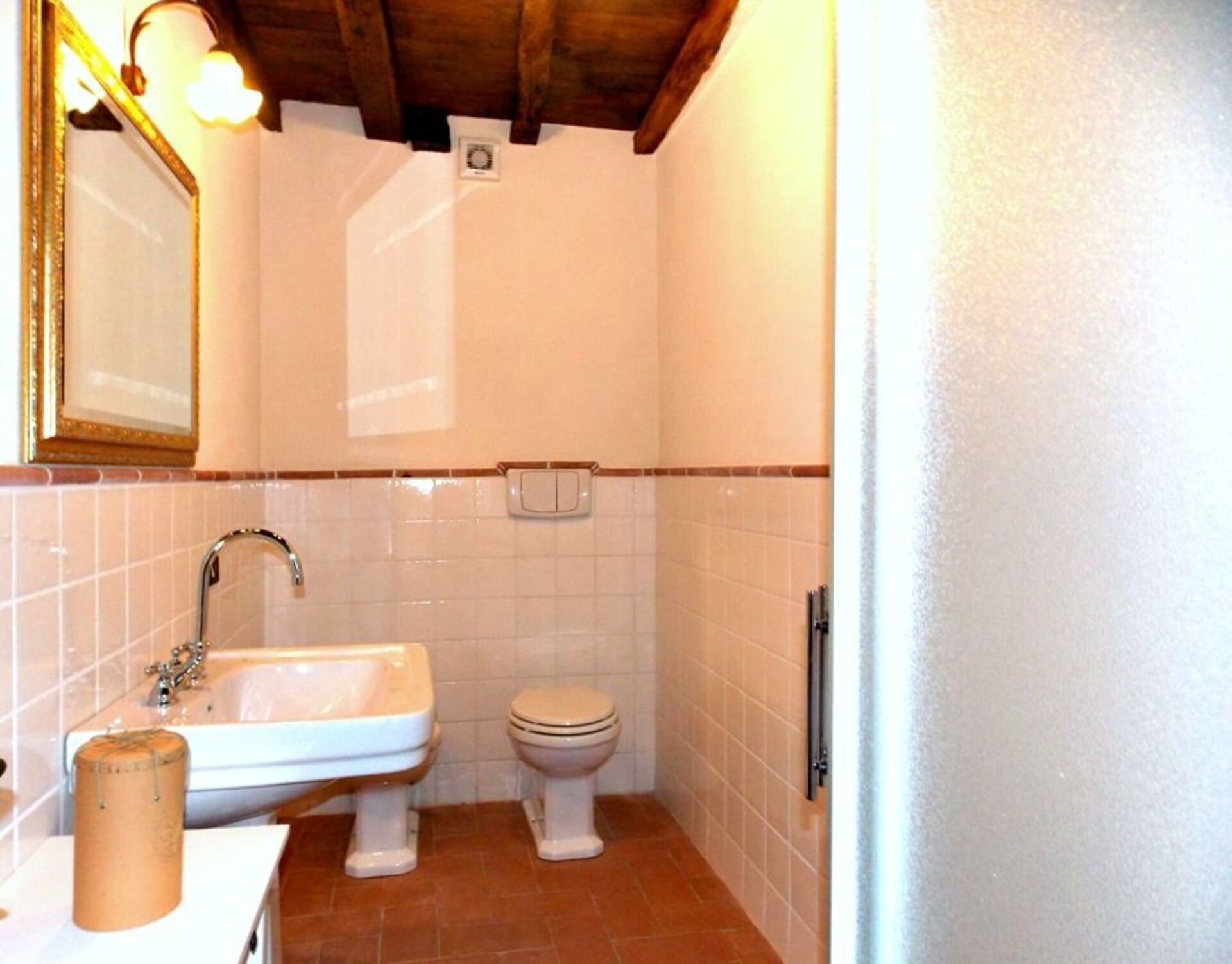 Une salle de bain avec un lavabo, des toilettes et un miroir.