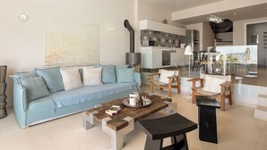 A modern living room with a sofa, coffee table, and dining area.