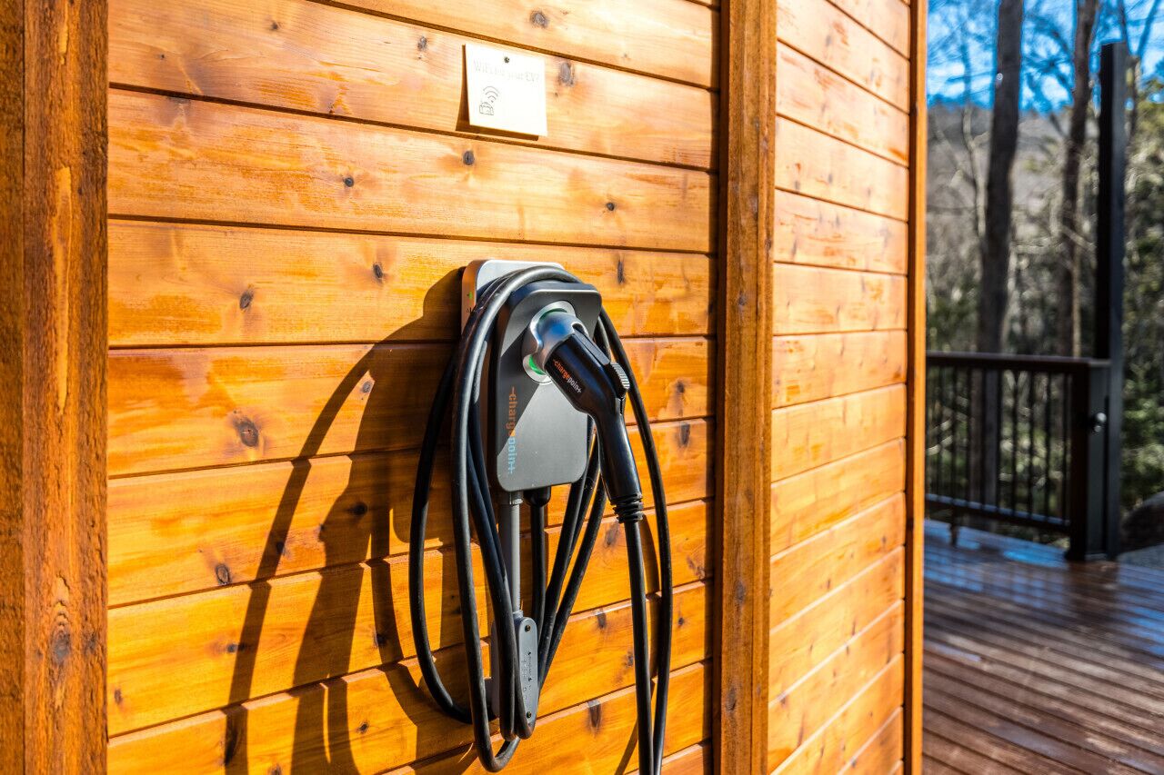 Eine Ladestation, die an einer Holzwand angebracht ist, mit einem Holzboden im Hintergrund.