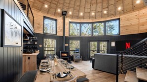 A modern interior with a dining area, a fireplace, and a Netflix logo on the wall.