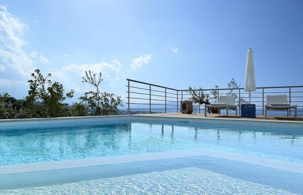 Relax by the pool surrounded by lush greenery and a breathtaking mountain view.