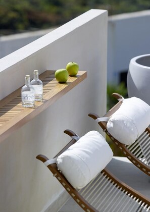 Relax in a serene outdoor space with two lounge chairs and a tranquil view of the surrounding greenery.