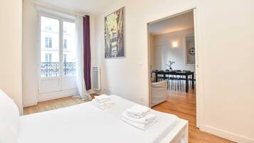 2 habitaciones, escritorio y tabla de planchar con plancha