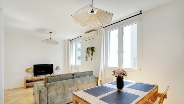Una sala moderna con un sofá, una mesa de comedor y un televisor.
