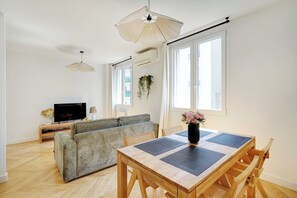 Una sala moderna con un sofá, una mesa de comedor y un televisor.