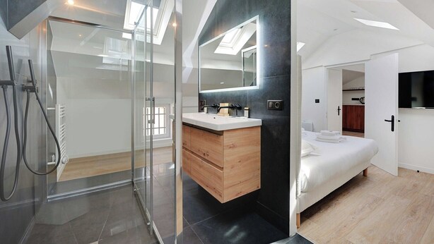A modern bedroom with a glass shower, a wooden vanity, and a large mirror. - Superb apartment - 1BD/4P - Aubervilliers (Aubervilliers)