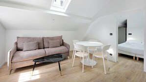 A modern, compact room with a loft-style ceiling, a sofa, a dining table with chairs, and a bed. - Superb apartment - 1BD/4P - Aubervilliers (Aubervilliers)