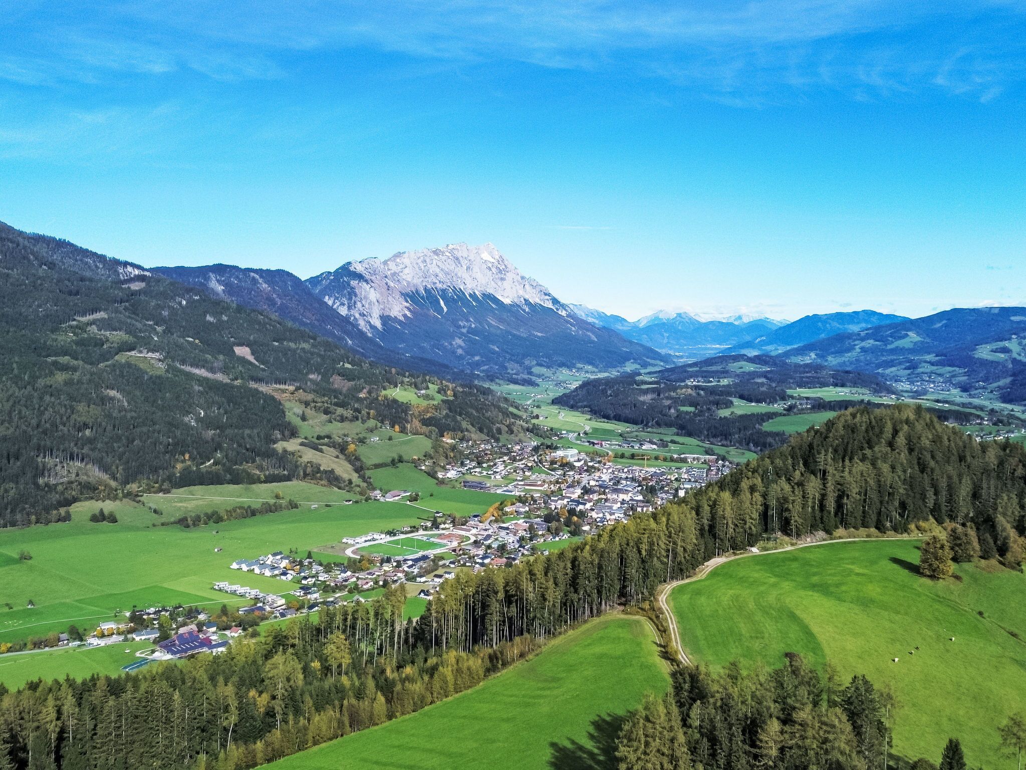 A panoramic view of a town nestled in a valley with a prominent mountain in the background.