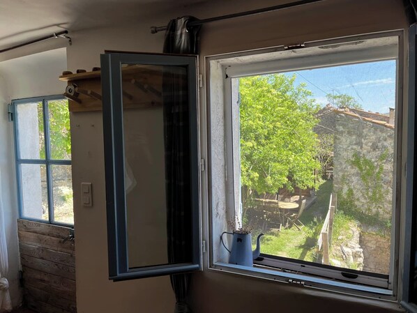 Una habitación con un ventanal grande, paredes de madera y una estantería de metal.