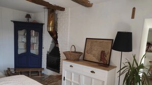 A cozy room with a fireplace, a blue cabinet, a wooden bench, and a bed. - Domaine du Cruvelet (Trigance)