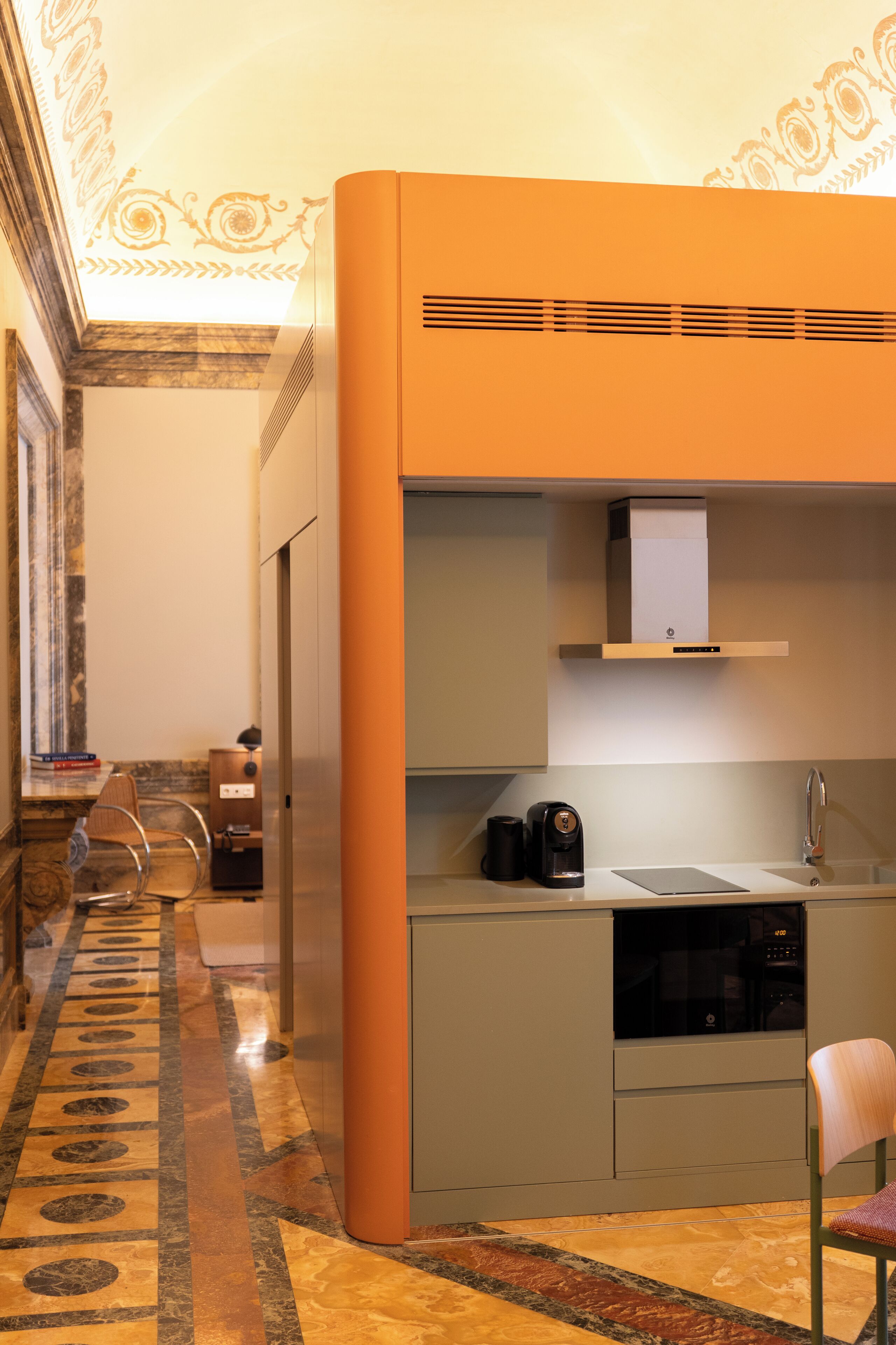 A compact kitchen with a microwave, coffee maker, and a sink.