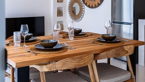 Ein moderner Essbereich mit Holztisch, gewebten Pendelleuchten und dekorativen Wandplatten.