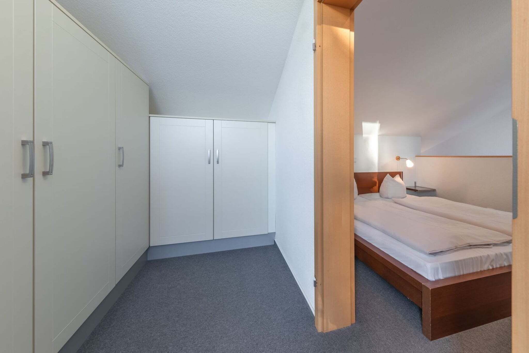 Ein Schlafzimmer mit einem Bett, einem Nachttisch und einem Kleiderschrank.