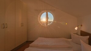 A bedroom with a skylight, a bed, and a wardrobe. - elegant eingerichtete Ferienwohnung (Granzow)