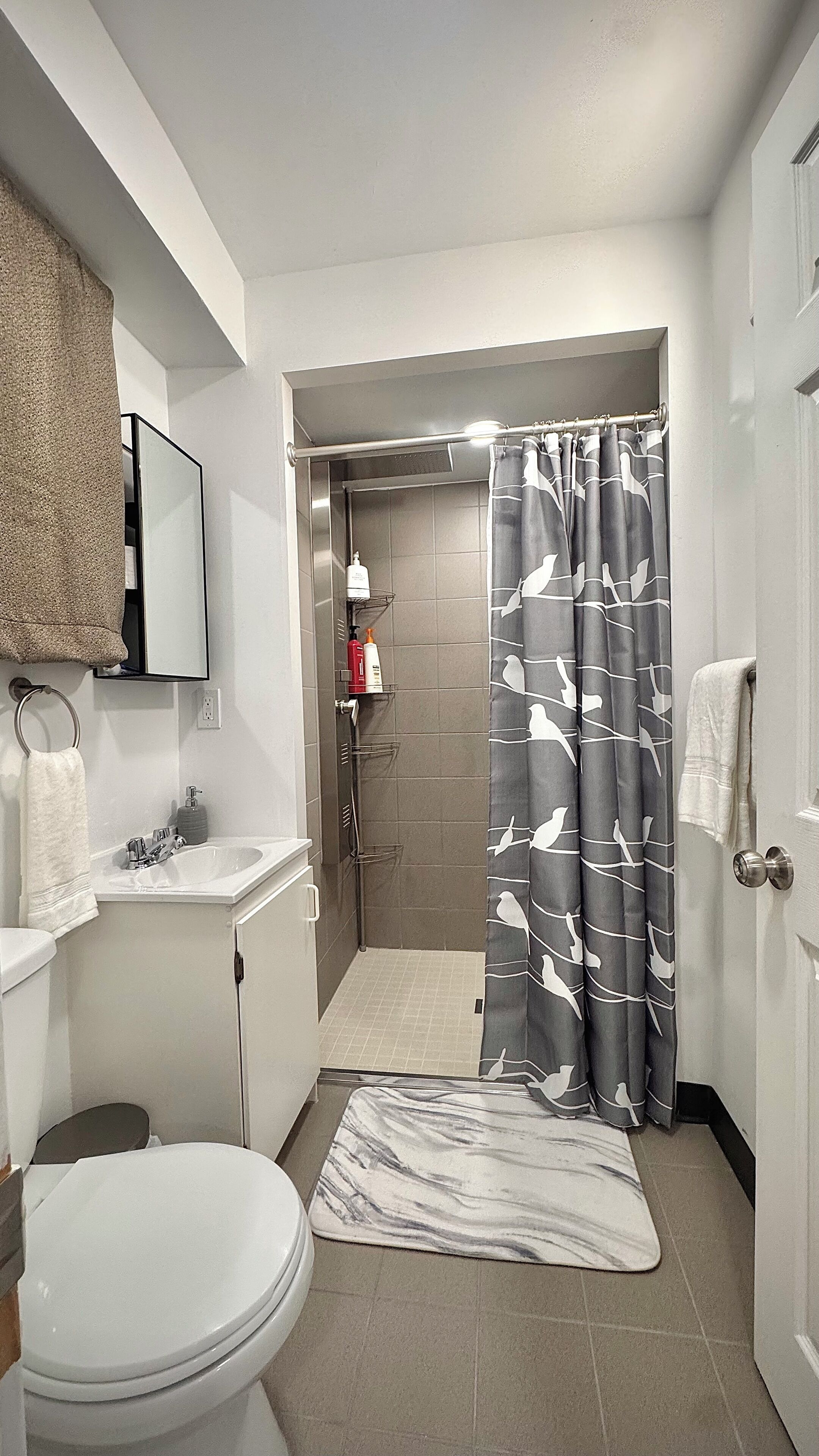 Une salle de bain équipée d’une douche, de toilettes, d’un lavabo et d’un porte-serviettes.