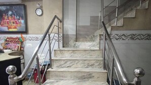 A marble staircase with metal railings and handrails, leading to an upper floor. - Hotel Ishaan International (Reasi)