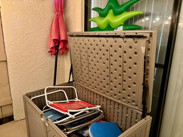 Un depósito para objetos con un panel trasero perforado, una toalla roja colgada de un gancho y una decoración en forma de estrella verde en la parte superior.