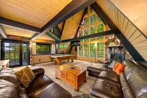 Ein gemütliches Zimmer mit Billardtisch, Ledersofa und Kamin.