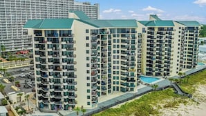 A multi-story hotel with balconies, a swimming pool, and a beach view. - Ocean Front Beach Condo (Panama City Beach)