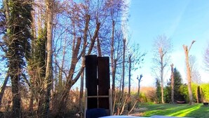 Un bain à remous avec vue sur les arbres et une structure en bois en arrière-plan.