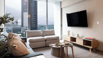 Un salon moderne avec un canapé, une table basse et un téléviseur fixé au mur.